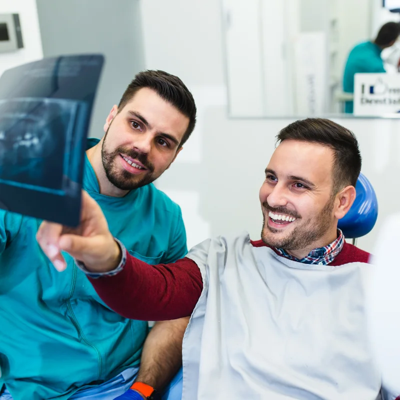 Dentist showing a dental X-ray to a patient during an Invisalign consultation at Riverfront Dental in Cambridge Ontario