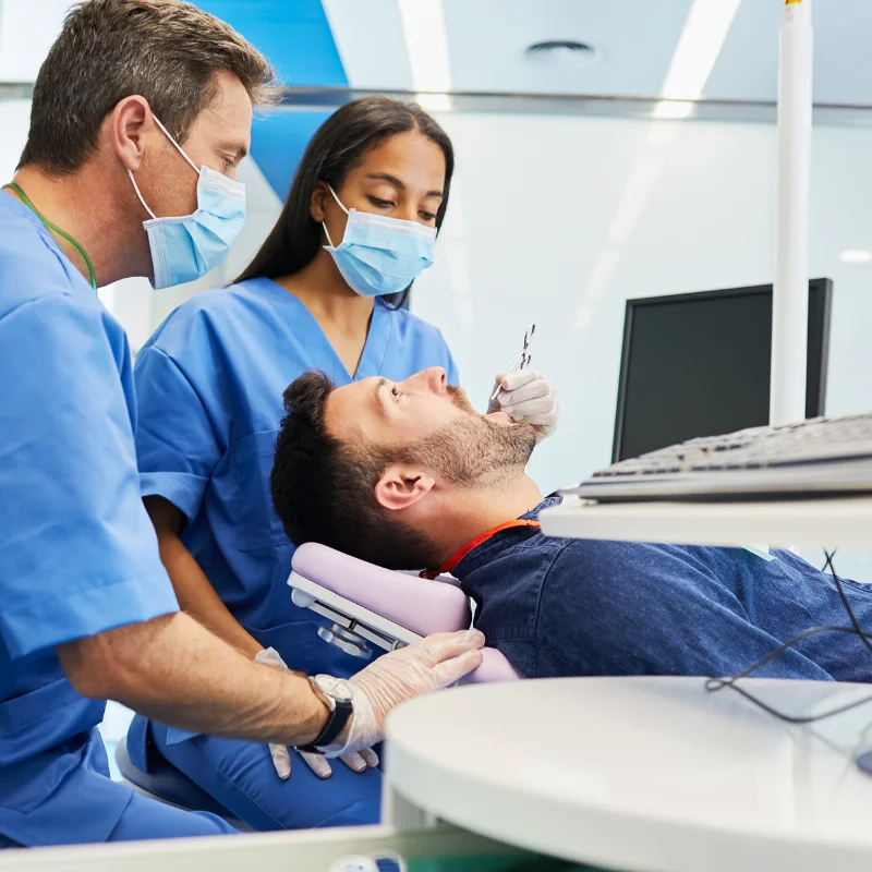 Dental team preparing a patient for oral surgery treatment while examining the mouth at Riverfront Dental in Cambridge Ontario