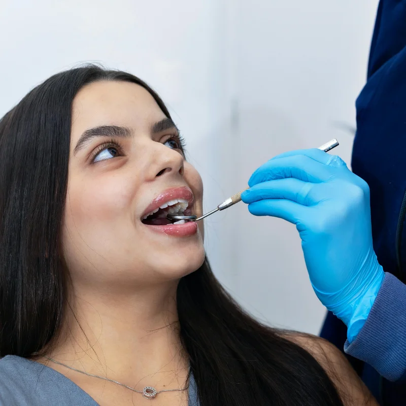 Dentist examining a patient’s teeth during a teeth whitening consultation at Riverfront Dental in Cambridge Ontario