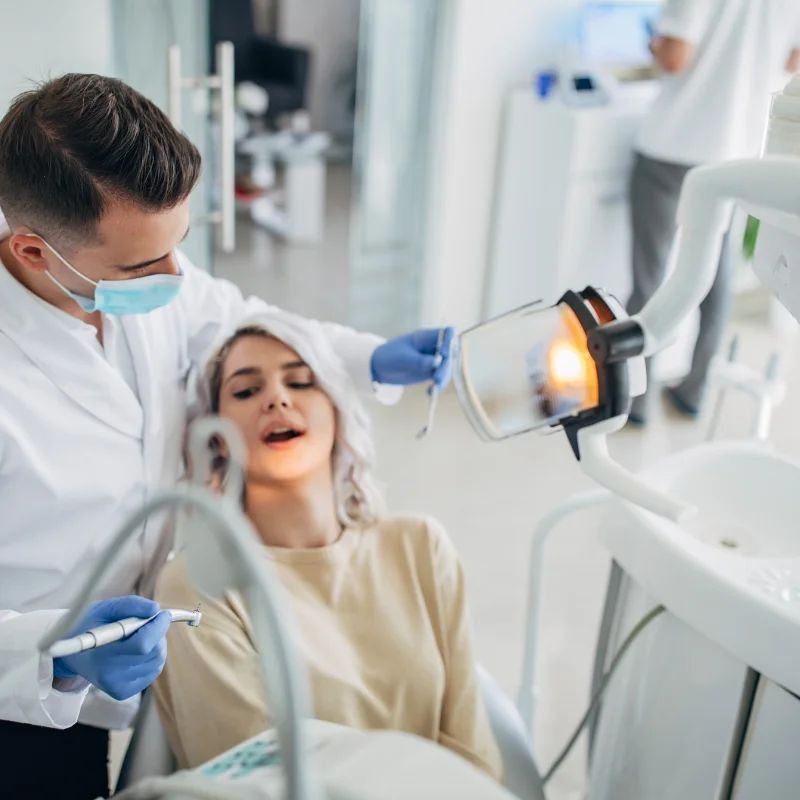 Dentist performing an endodontic root canal procedure on a patient in a dental chair at Riverfront Dental in Cambridge Ontario