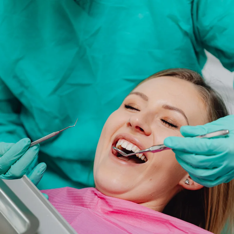 Patient receiving dental restoration treatment while a dentist examines teeth with dental tools at Riverfront Dental in Cambridge Ontario