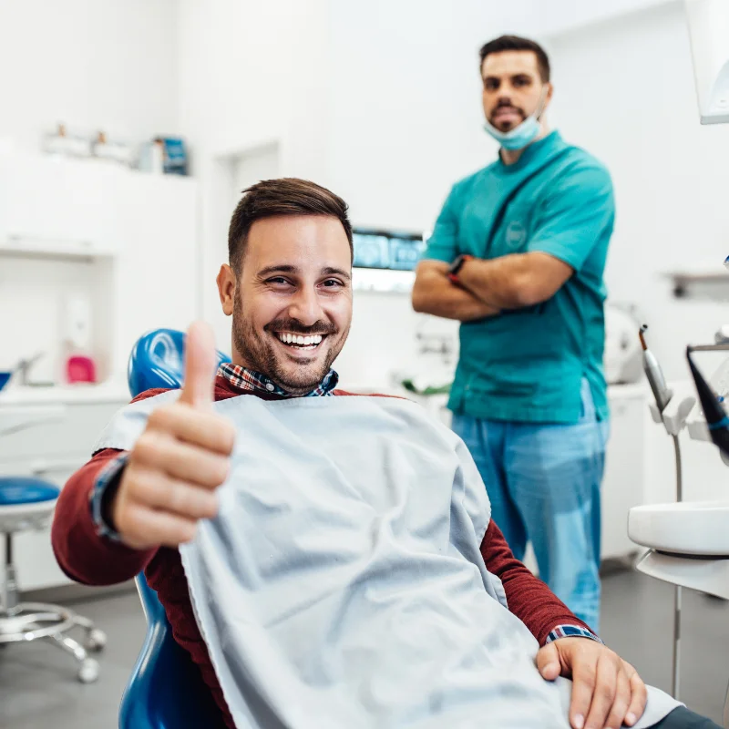 Smiling patient giving a thumbs up after a dental appointment at Riverfront Dental clinic in Cambridge Ontario