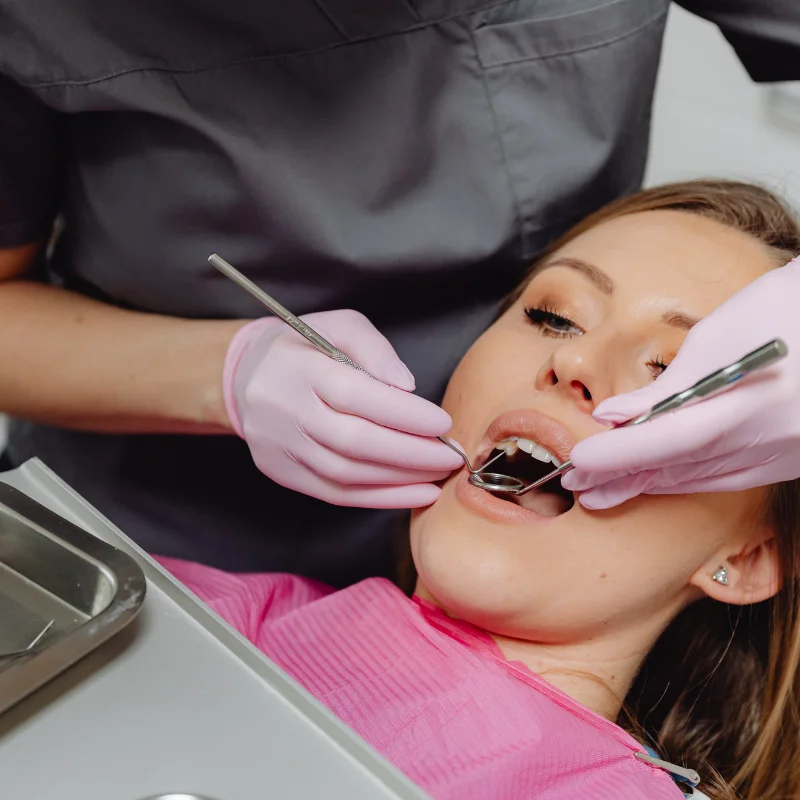 Dentist performing cosmetic dental treatment using dental mirror and tools on a patient at Riverfront Dental in Cambridge Ontario
