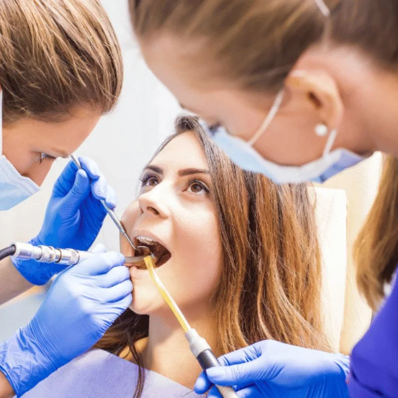 Dentist and dental assistant performing a dental implant procedure on a patient at Riverfront Dental in Cambridge Ontario