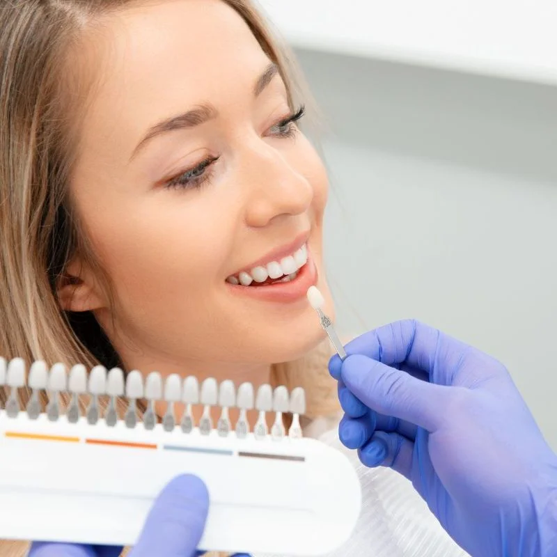 Dentist matching veneer shade with a smiling patient during cosmetic dentistry consultation at Riverfront Dental in Cambridge Ontario
