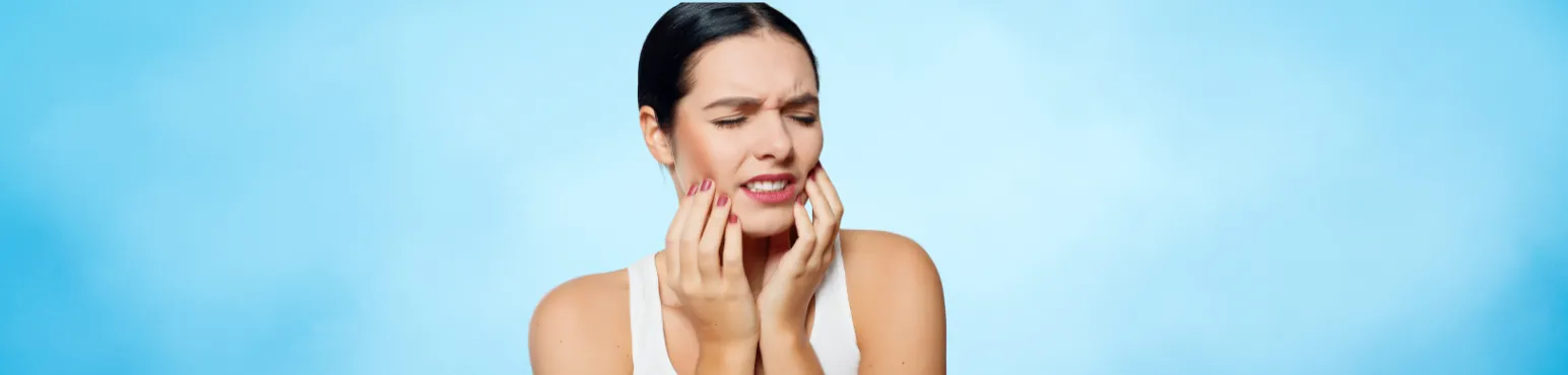 Emergency Dentist in Cambridge ON at Riverfront Dental Woman holding her jaw in pain representing emergency dental care at Riverfront Dental in Cambridge ON