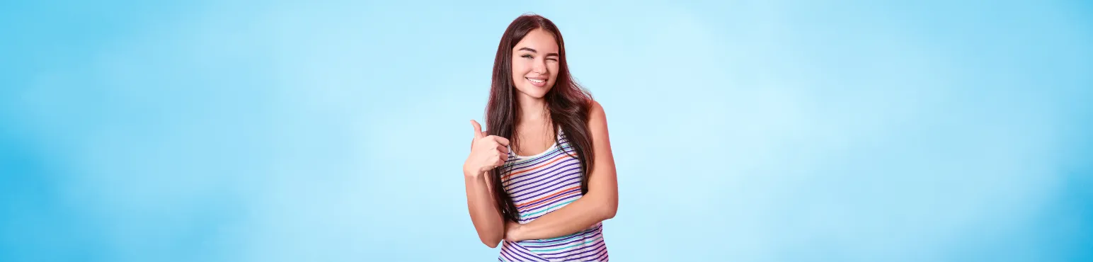 Wisdom Tooth Extraction at Riverfront Dental Cambridge ON Young woman smiling and giving thumbs up after wisdom tooth extraction at Riverfront Dental in Cambridge ON